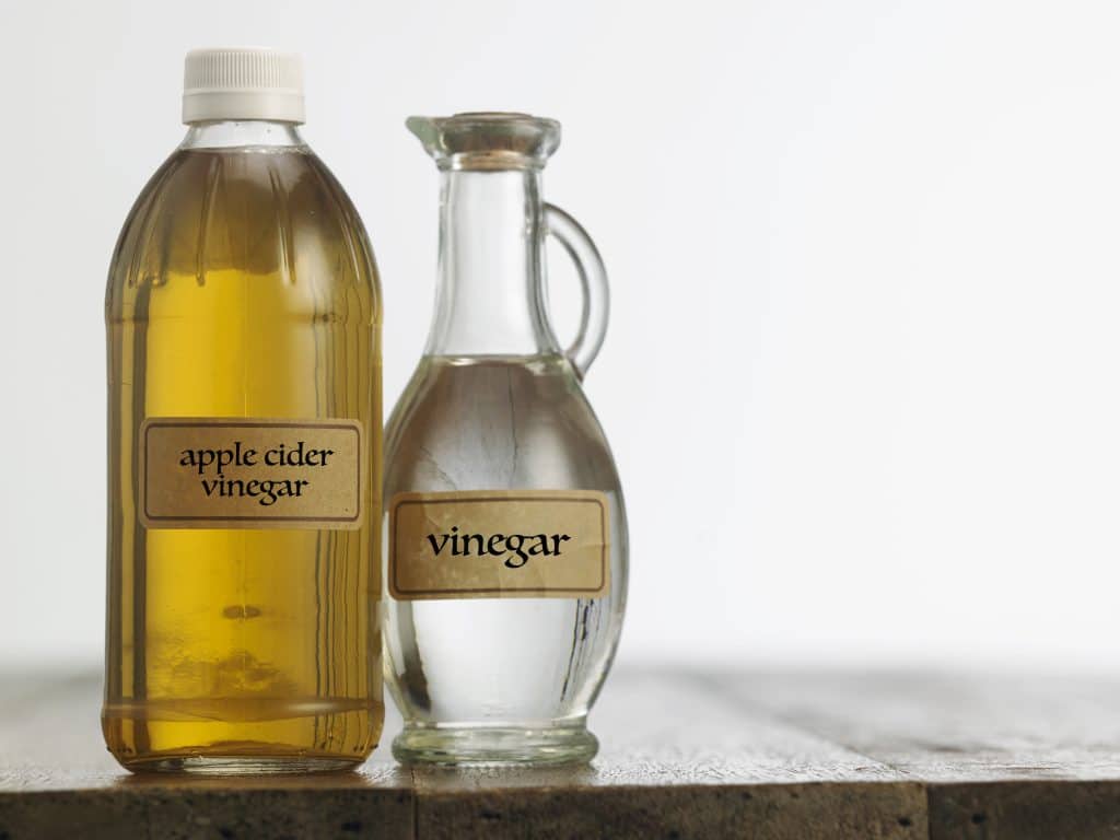 Apple cider vinegar and white vinegar on the wooden table top