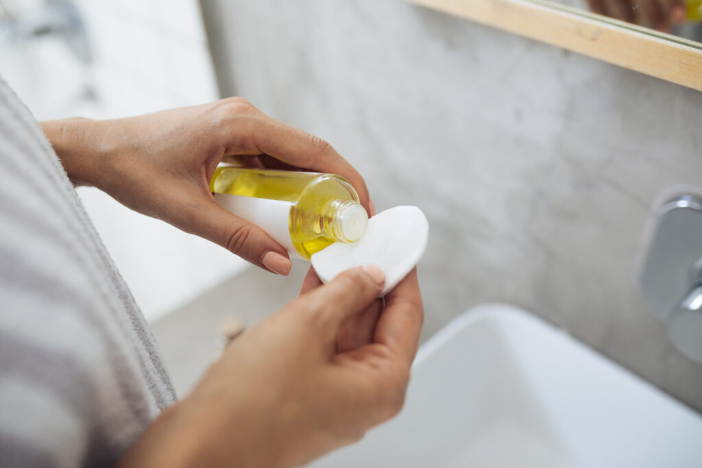 Applying natural health oil to cotton pad for application