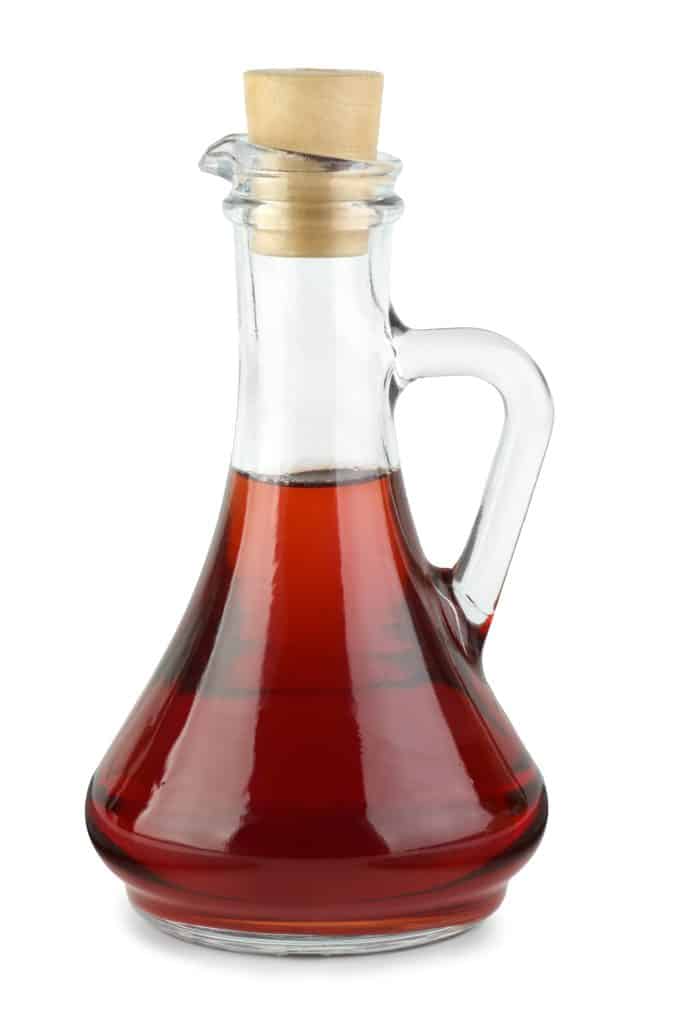 Decanter with red wine vinegar  isolated on the white background