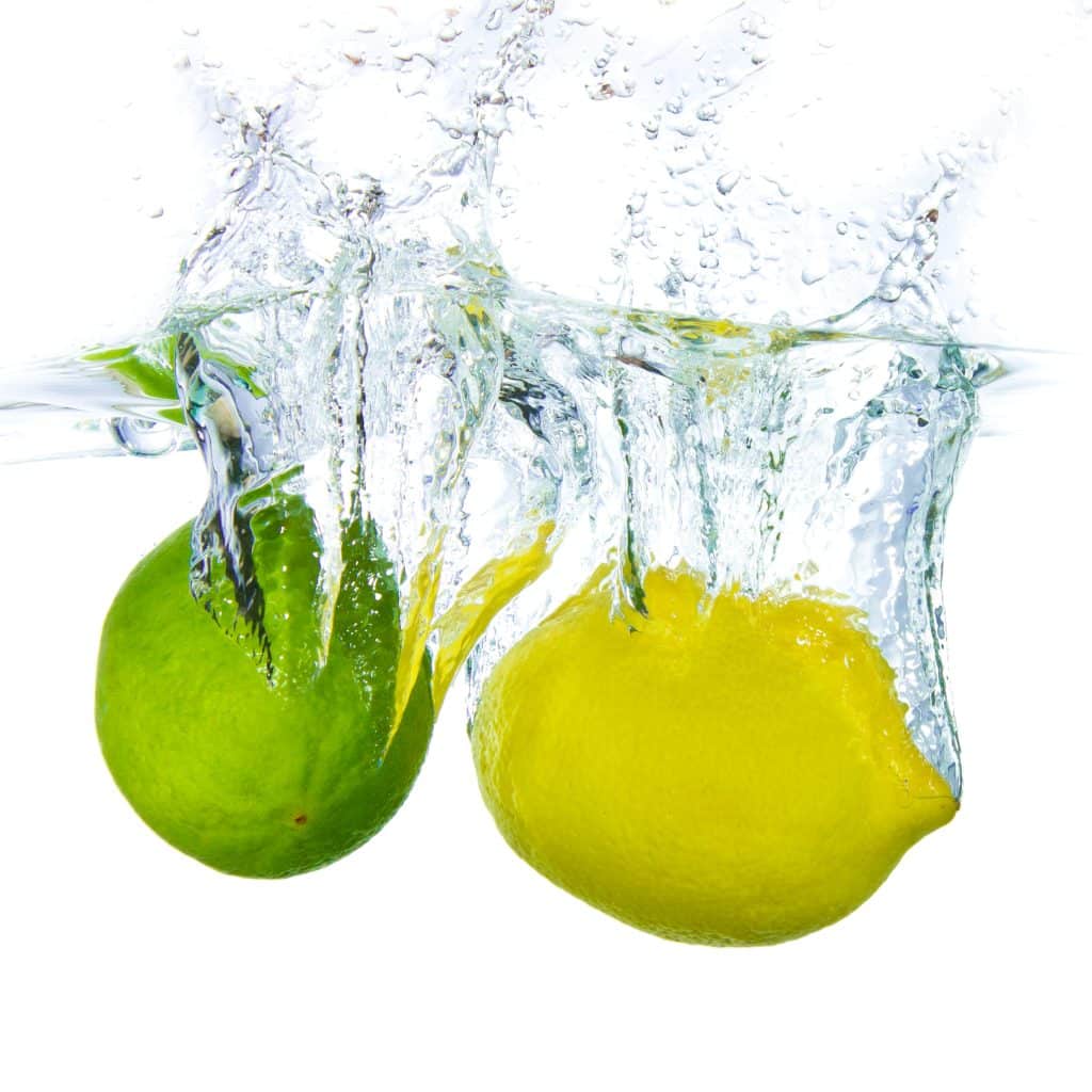 lime and lemon splashing water isolated on white background